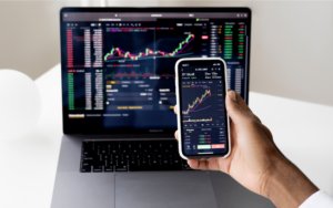 Investor reviewing a share portfolio and financial documents before selling or transferring shares.