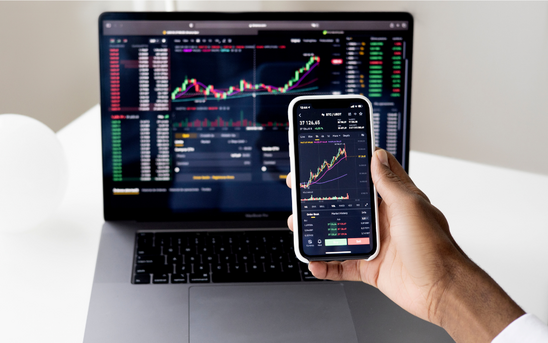 Investor reviewing a share portfolio and financial documents before selling or transferring shares.